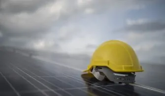 Yellow safety helmet on solar cell panel